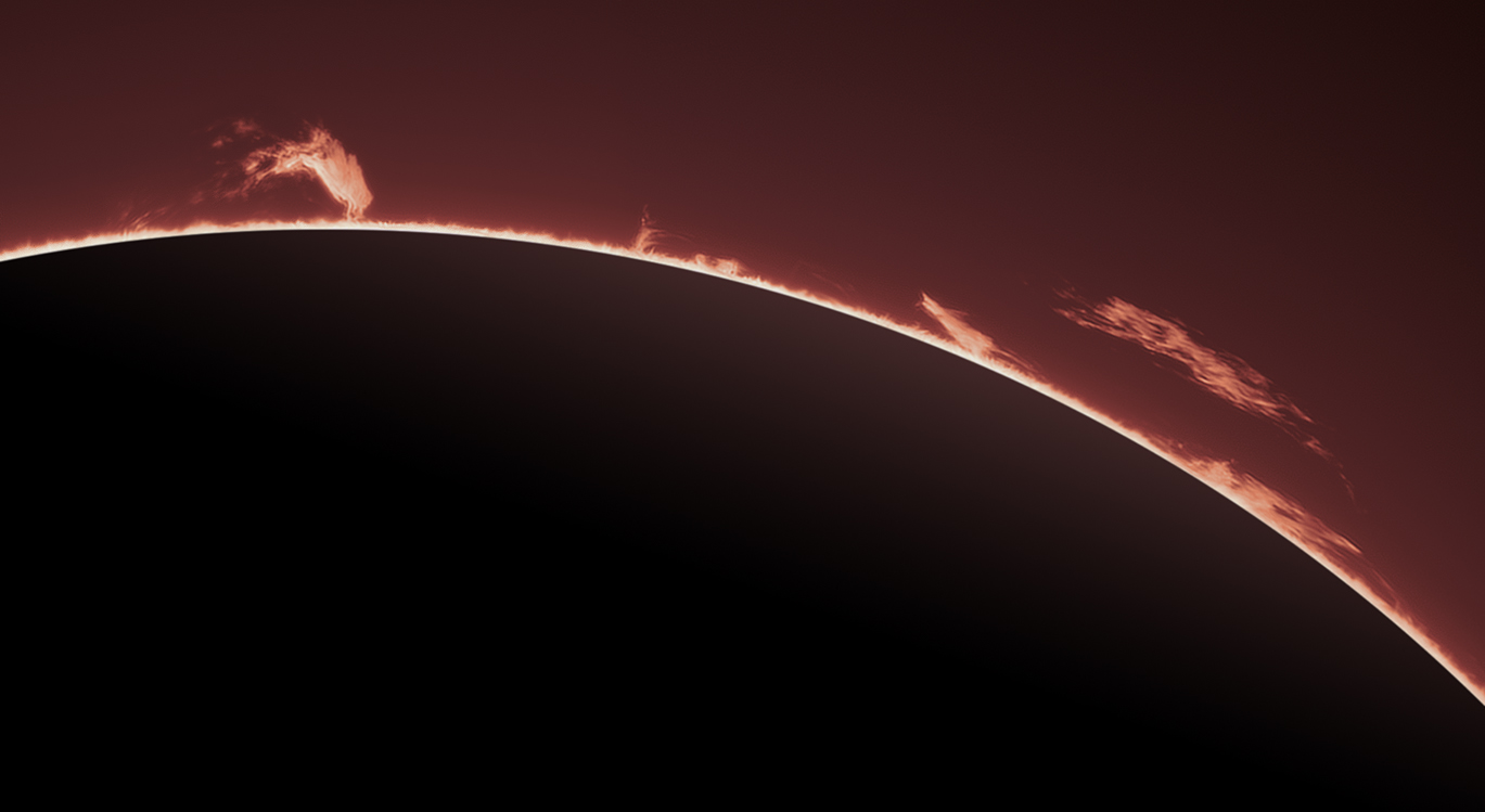 Solar prominences rise off a sillhouetted sun